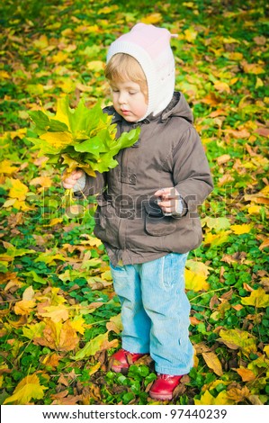The small child walks in autumn park