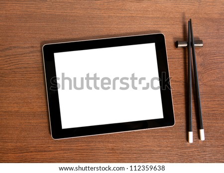 Tablet with isolated screen on a tablet touch computer gadget near sushi