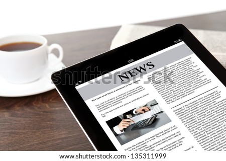 computer tablet with business news on screen on a table at a businessman in office