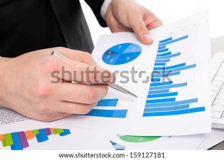 businessman in the office of the table points to the graphics