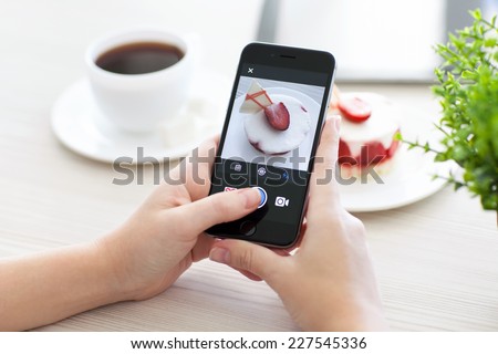 Alushta, Russia - October 28, 2014: Woman holding a iPhone 6 Space Gray with social networking service Instagram on the screen. iPhone 6 was created and developed by the Apple inc.