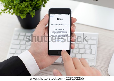 Alushta, Russia - November 3, 2014: Businessman holding a iPhone 6 Space Gray with service Apple Pay on the screen. iPhone 6 was created and developed by the Apple inc.
