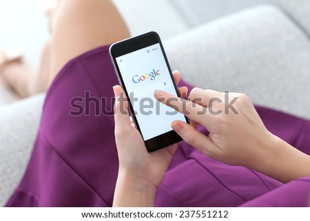 Alushta, Russia - November 22, 2014: Woman holding a iPhone 6 Space Gray with social networking service Google on the screen. iPhone 6 was created and developed by the Apple inc.
