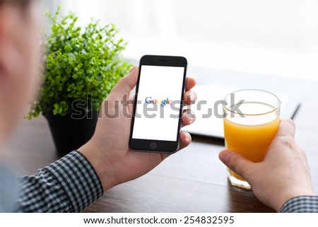 Alushta, Russia - November 21, 2014: Man holding a iPhone 6 Space Gray with social networking service Google on the screen. iPhone 6 was created and developed by the Apple inc.