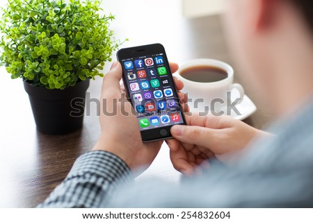 Alushta, Russia - November 20, 2014: A set of programs from famous brands of social networking on the phone iPhone 6 in man hands. iPhone 6 was created and developed by the Apple inc.
