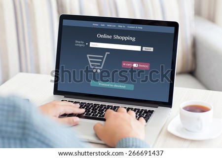 man sitting at a computer and makes online shopping in the room