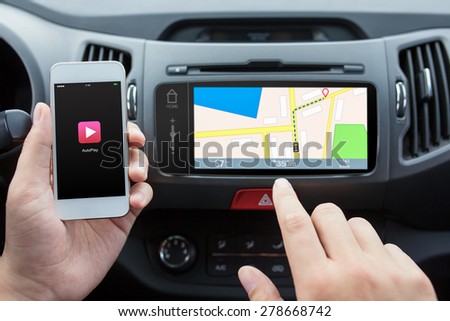 man connecting phone with auto play to the car media system with navigation map