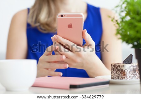 Alushta, Russia - October 25, 2015: Woman holding in the hand iPhone6S Rose Gold in cafe. iPhone 6S Rose Gold was created and developed by the Apple inc.