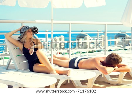 Series man and woman lying on chaise lounges on a yacht in the ocean