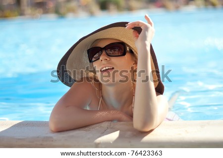 Series the smart blonde in a hat in pool of expensive hotel