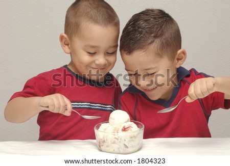 Two preschool brothers prepare to enjoy a large bowl of strawberry-cheesecake  ice cream