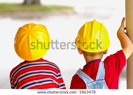 Two boys wearing hard hats viewed from behind