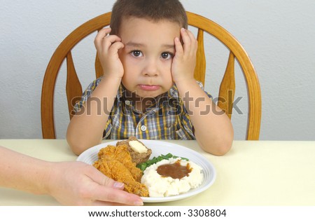 A young boy ready to eat his fried chicken dinner