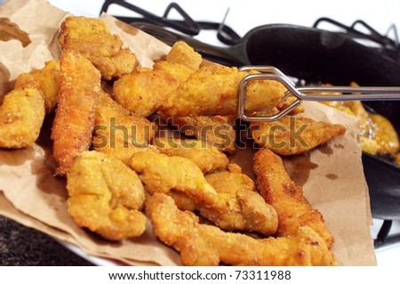 golden-brown deep-fried chicken pieces draining on paper towel