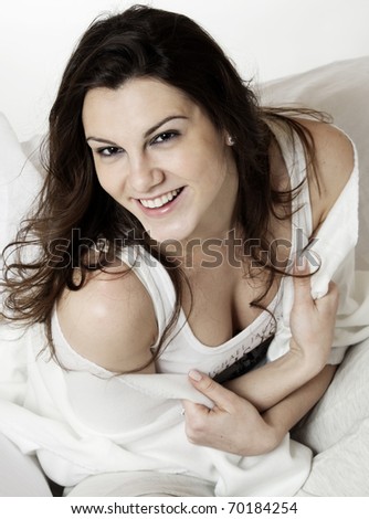 Laughing young beautiful woman sitting on the sofa