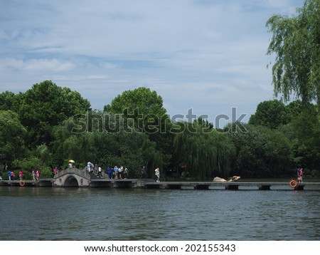 HANGZHOU, CHINA - MAY 22: Visitors visit the infamous West Lake on May 22, 2014 in Hangzhou, China. It was made a UNESCO World Heritage Site in 2011.