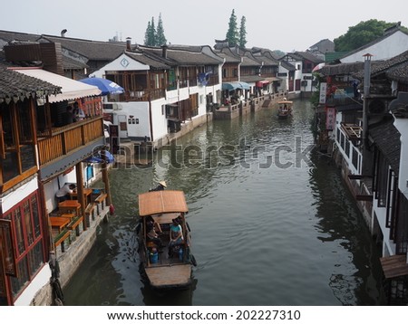 ZHUJIAJIAO, CHINA - MAY 21: Senior man transports recycling material in Chinese gondola on May 21, 2014 in Shanghai. Zhujiajiao is a well-known ancient water village  as Shanghai\'s version of Venice