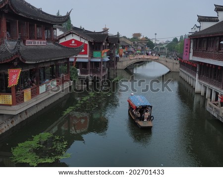 QIBAO, SHANGHAI - MAY 20: boats in the main canal and an old bridge on May 20, 2014 Qibao, Shanghai, China. Qibao water village is Shanghai tourist attraction with 1000000 visitors year.