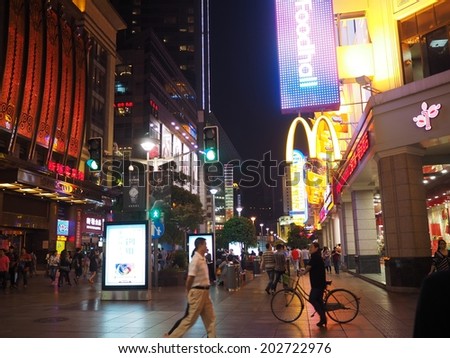 SHANGHAI,CHINA - MAY 23: Tourists at the famous shopping street, Nanjing road, in Shanghai, China on May 23, 2014. Nanjing Road is one of the world\'s busiest and longest shopping district.