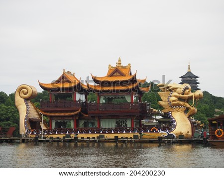 HANGZHOU, CHINA - MAY 23: Large dragon boats packed with tourists cruise the waters of the famous West Lake on May 23, 2014 in Hangzhou, China. It was made a UNESCO World Heritage Site in 2011.