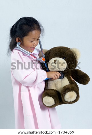 A young girl tends to her sick teddy bear.