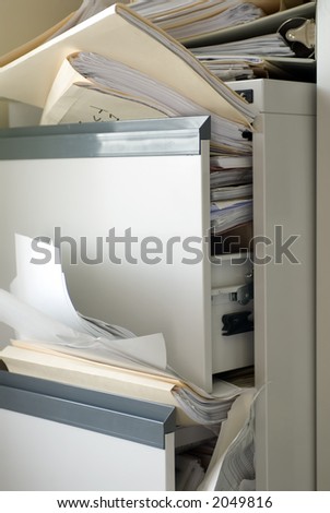 A file cabinet filled beyond capacity ... total disorder