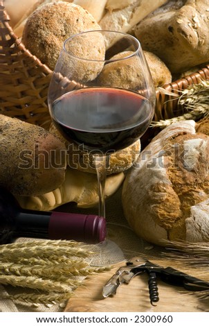 An inviting glass of red wine along with an assortment of fresh breads