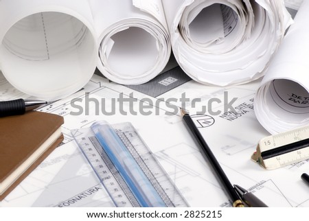 An engineer\'s work table with drawings and tools of the trade