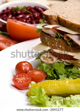A fresh deli sandwich with tomatoes swiss cheese, lettuce and lots of meat.