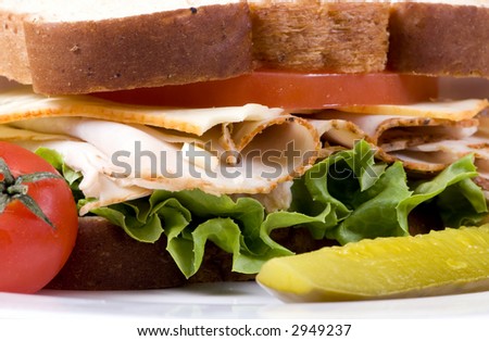 A fresh deli sandwich with tomatoes cheese, lettuce and lots of turkey meat.