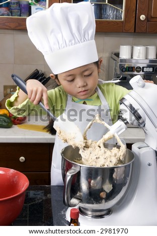 Two young sisters have fun in the kitchen making a mess....I mean making cookies. Education, learning, cooking, childhood