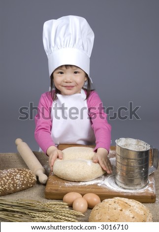 A young girl having fun in the kitchen making a mess....I mean making bread. Education, learning, cooking, childhood