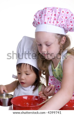 two young girls having fun in the kitchen making a mess....I mean making something special..... Education, learning, cooking, childhood