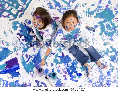Two young girls having fun painting everything. Childhood, learning, exploration family