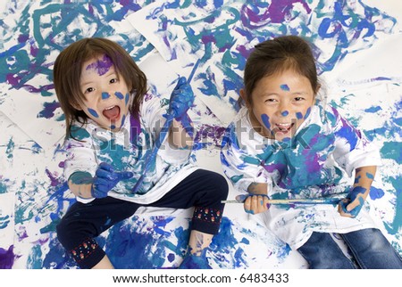 Two young girls having fun painting everything. Childhood, learning, exploration family