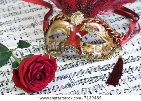 Two beautiful carnivale masks from venice Italy, on a sheet of music.