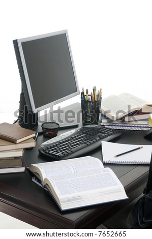 Piles of books open with a computer. Working on a research paper.