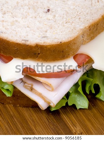 A fresh deli sandwich with tomatoes swiss cheese, lettuce and lots of meat.