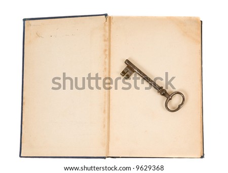 An old key sits on top of an old book. unlocking the past