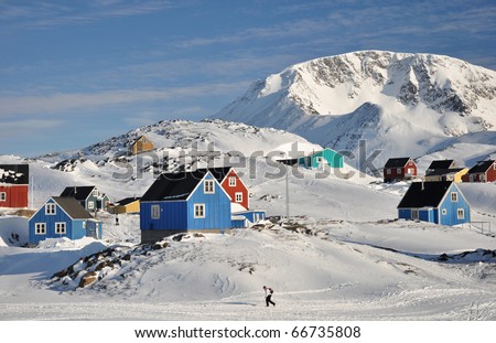 Colorful houses in the Kulusuk village and walking person, Greenland