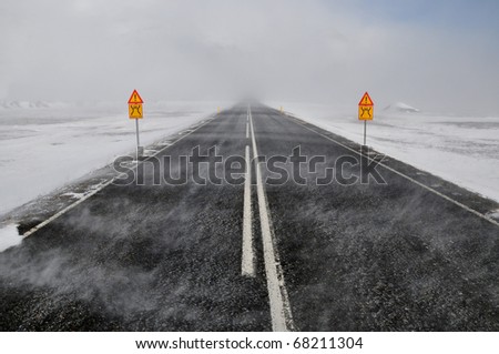 Road in a snow blizzard and two attention sing, Iceland