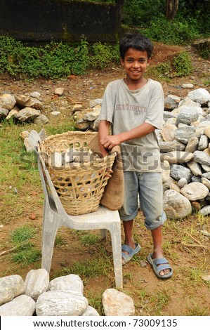 DARJEELING, INDIA - AUGUST 16: Unidentified young boy works hard as porter instead going to school on August 16, 2010. Child\'s work is a global problem. INDIA