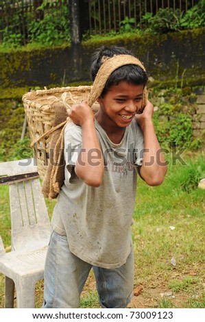 DARJEELING, INDIA - AUGUST 16: Unidentified young boy works hard as porters instead going to school on August 16, 2010. Child\'s work is a global problem. INDIA