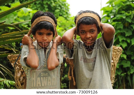 DARJEELING, INDIA - AUGUST 16: Unidentified young boys work hard as porters instead going to school on August 16, 2010. Child's work is a global problem. INDIA