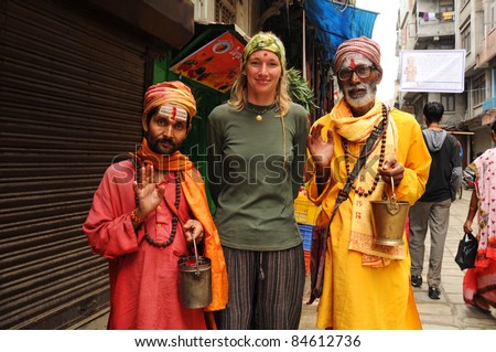 KATHMANDU, NEPAL - OCTOBER 1: Unidentified Nepalese holy men pose for picture with an European tourist on October 1, 2010 in Kathmandu, Nepal. The holy men pose for pictures in order to earn money.