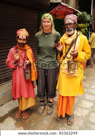 KATHMANDU, NEPAL - OCTOBER 1: Unidentified Nepalese holy men pose for picture with an unidentified European tourist on October 1, 2010 in Kathmandu, Nepal. The holy men pose for pictures in order to earn money.