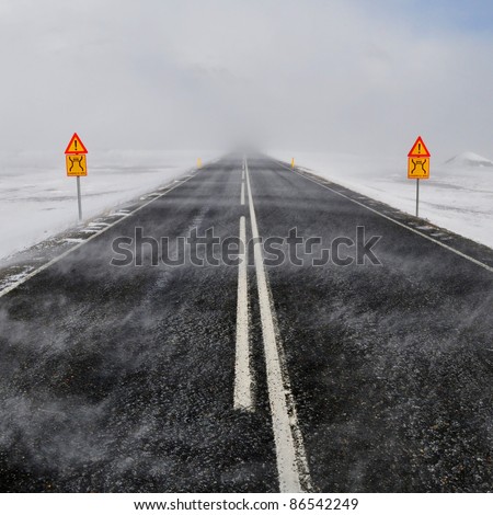 Road in a snow blizzard and two attention sing, Iceland