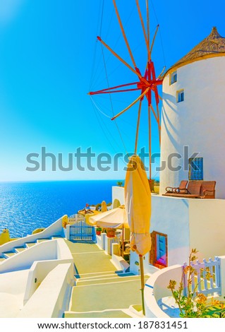 Amazing view to the sea including a pictorial old traditional windmill in Oia the most beautiful village of Santorini island in Greece