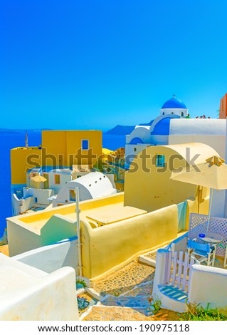 Tables and chairs on a terrace in a typical traditional house in Oia the most beautiful village of Santorini island in Greece