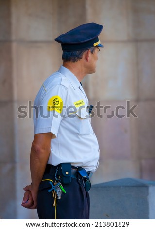 BARCELONA, SPAIN -AUG 27, 2009: Unidentified private security observing, out of the famous Sagrada Familia church in Barcelona, Spain on Aug 27, 2009.